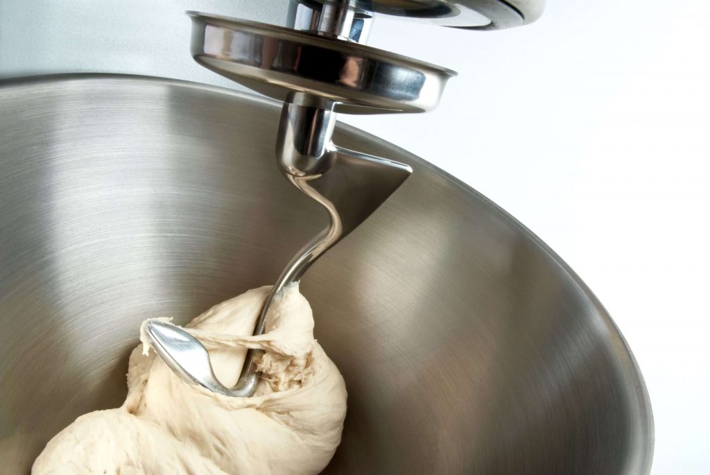 Hak robota kuchennego wyrabiający ciasto w dużej, metalowej misie