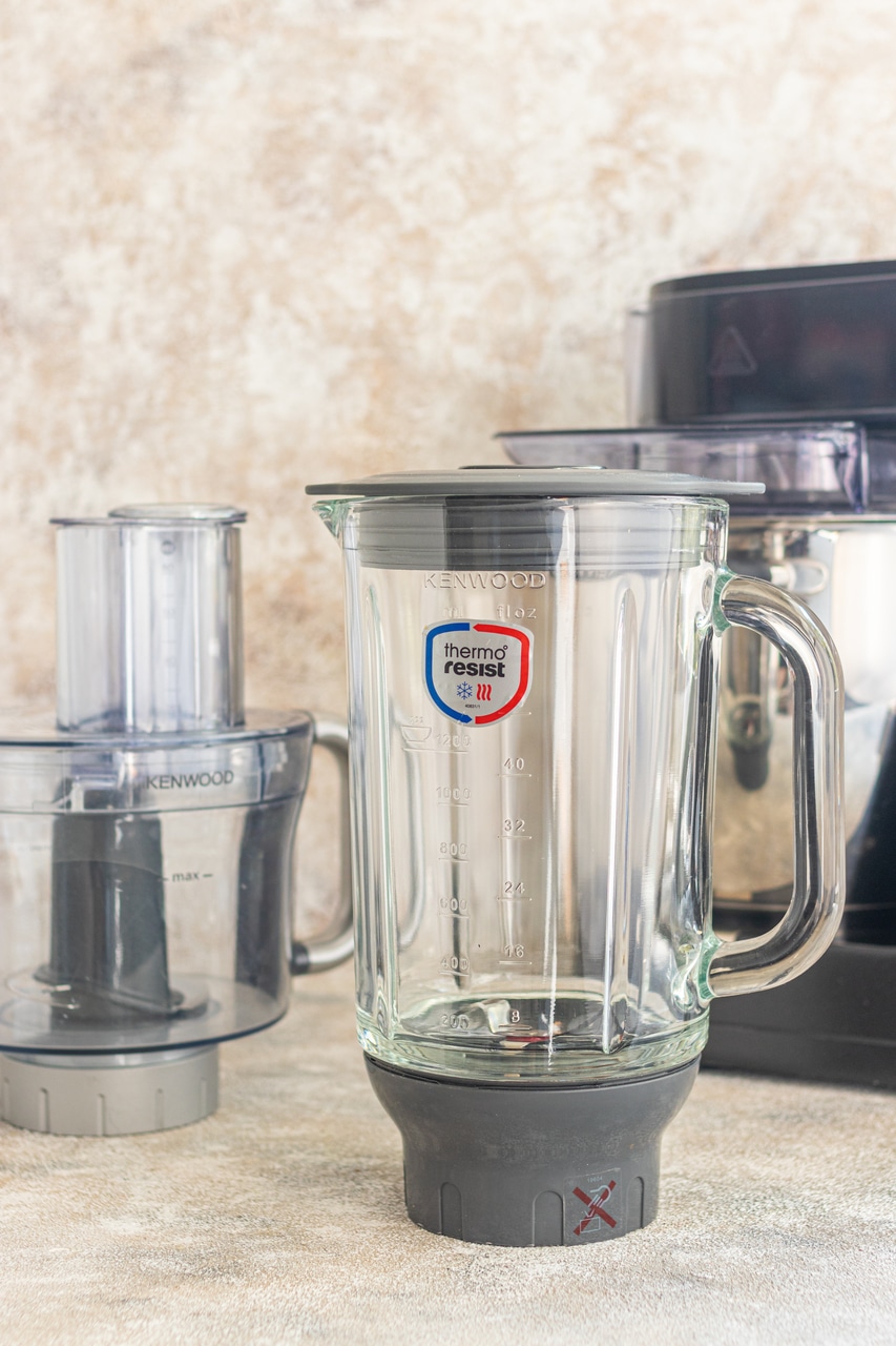 Szklany blender kielichowy i malakser stoją na białym blacie