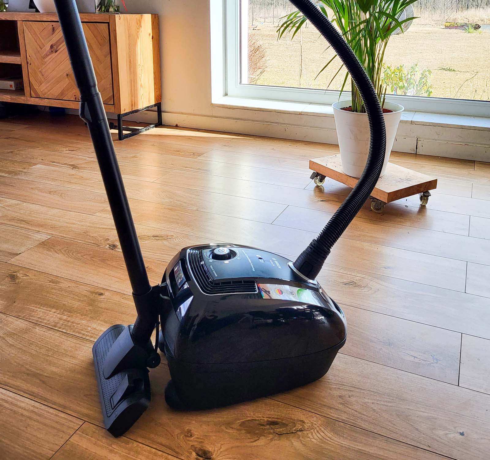 Odkurzacz Bosch Serie 4 BGB38BA3T stojący w salonie z przypiętą rurą
