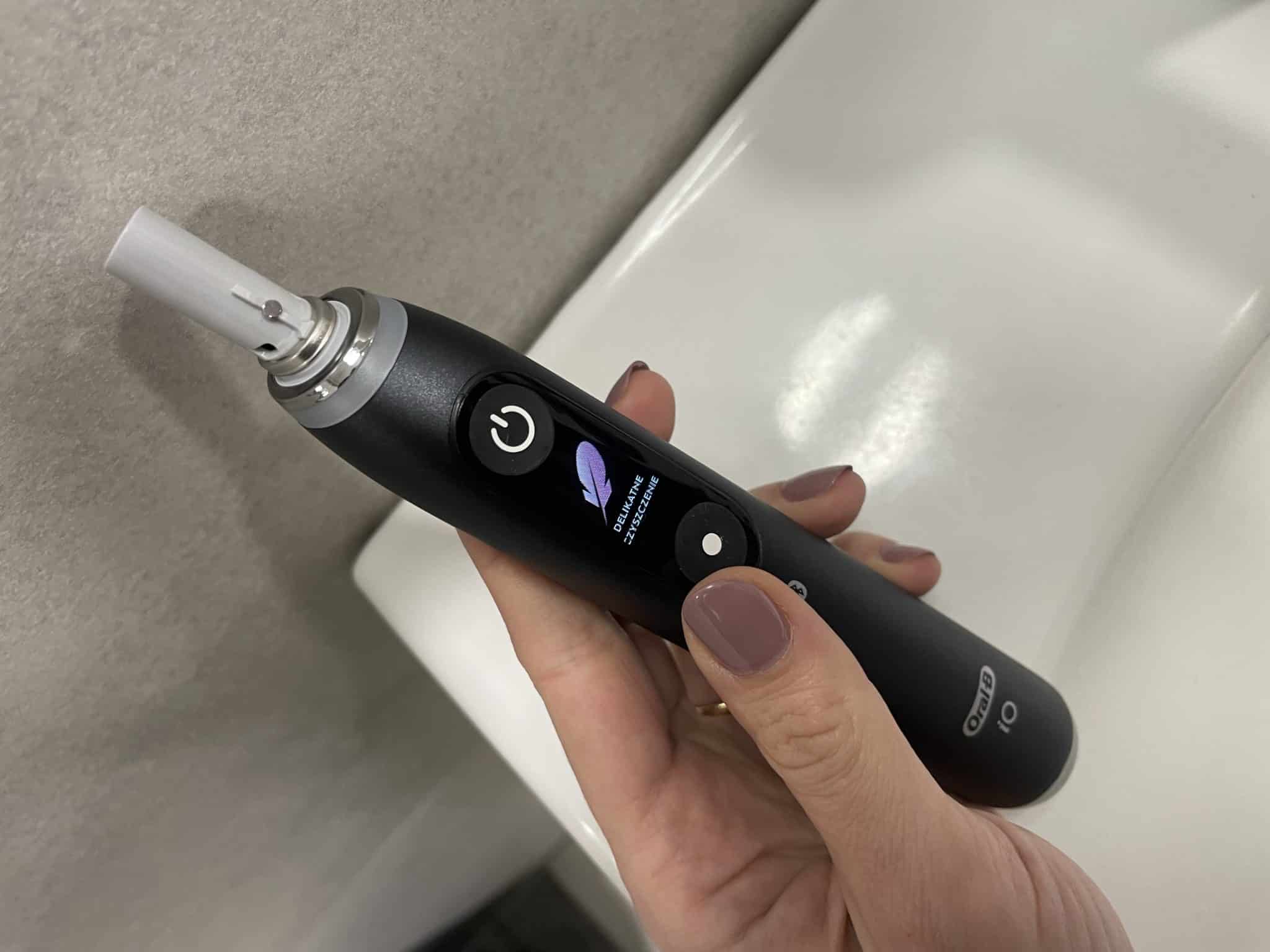 Dłoń trzymająca rączkę szczoteczki Oral-B iO 9N