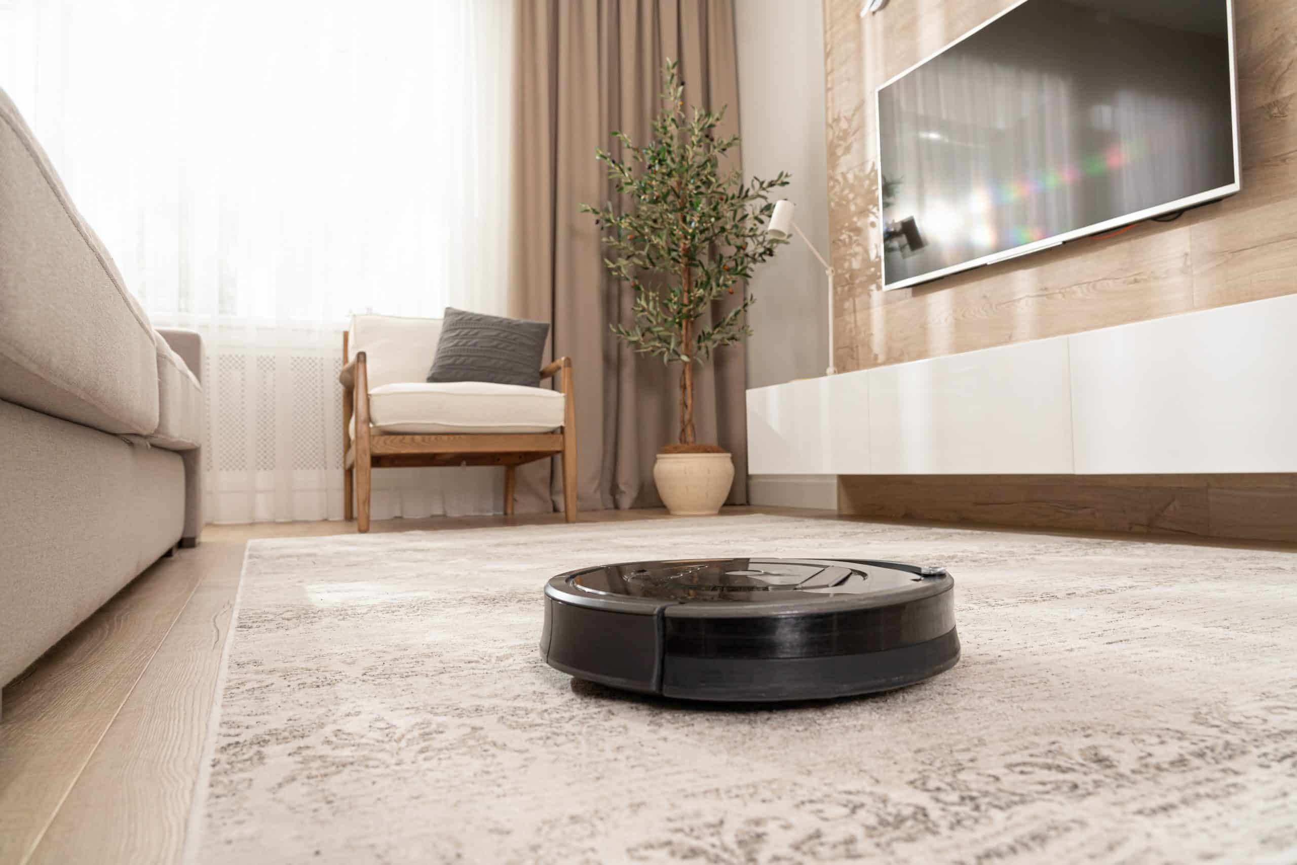 Czarny robot sprzątający na dywanie w salonie
