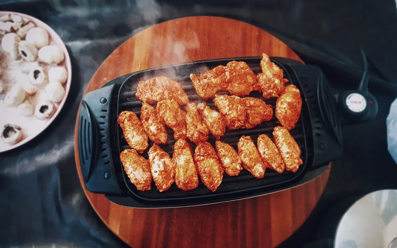 kawałki mięsa pieką się na stołowym grillu elektrycznym