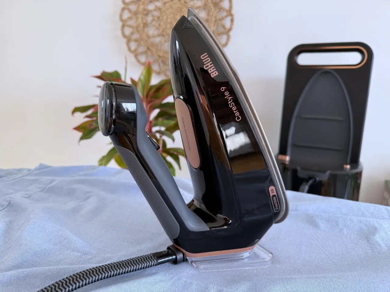 żelazko z generatorem pary Braun CareStyle 9 stoi na błękitnej koszuli