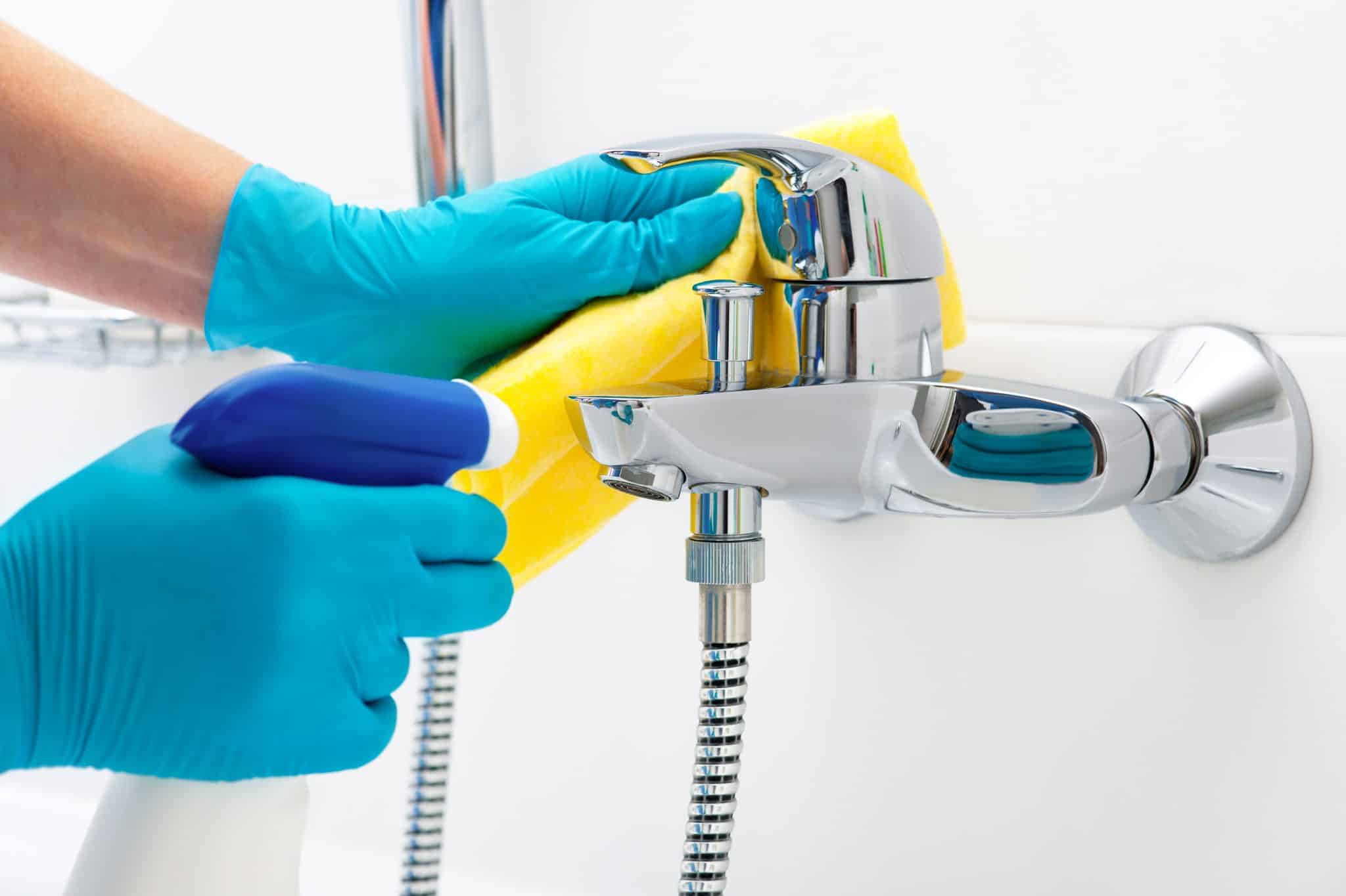 Usuwanie kamienia z baterii prysznicowej przy pomocy ściereczki i detergentu w sprayu