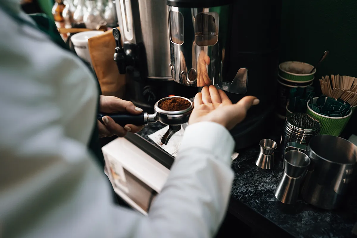 Barista robi kawę w ekspresie automatycznym