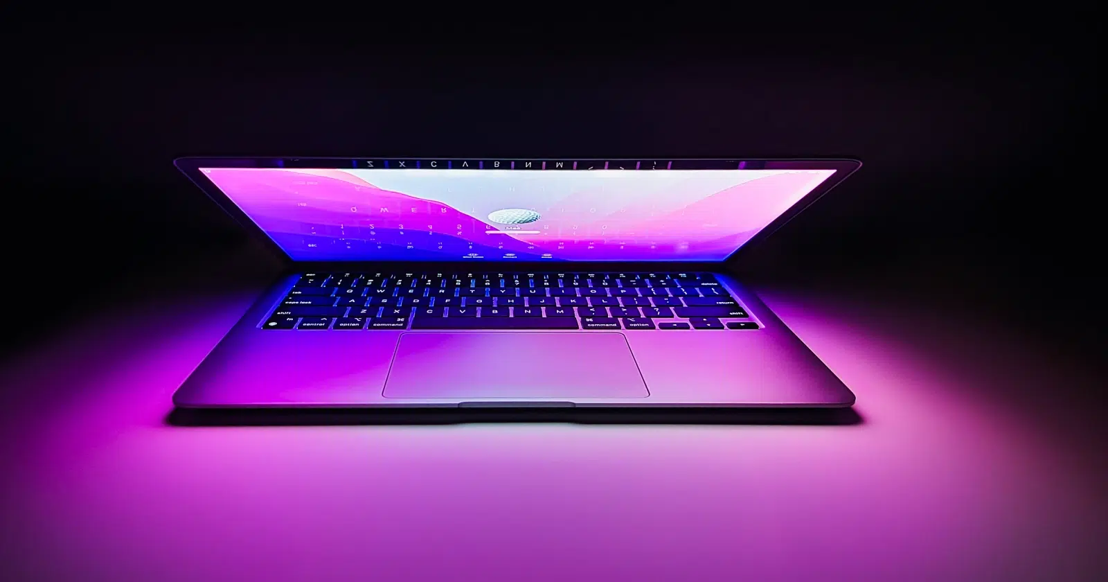 otwarty MacBook Pro M3 z najnowszym procesorem Apple i ekranem podświetlonym na fioletowo