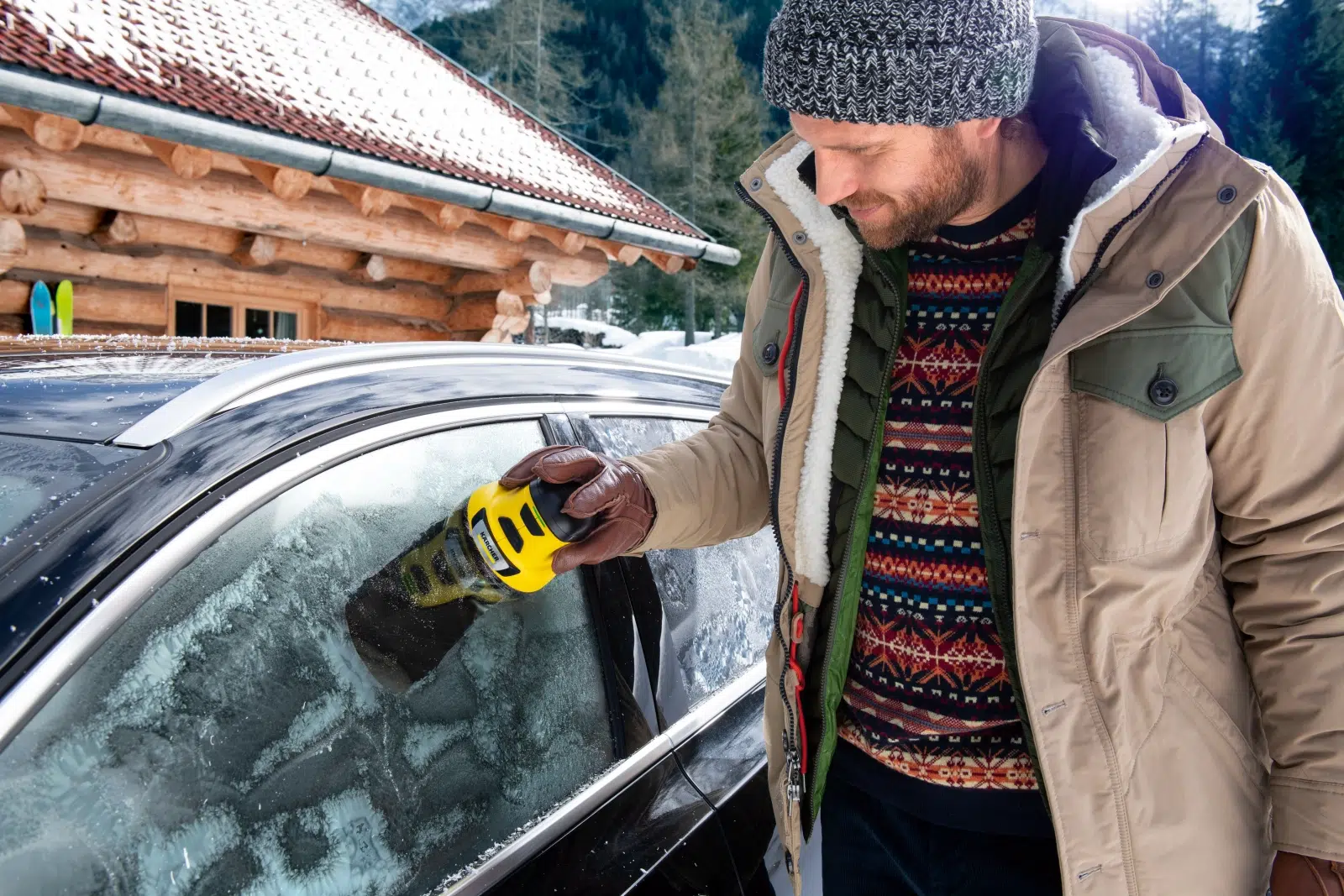 mężczyzna usuwa szron z samochodowej szyby przy pomocy elektrycznej skrobaczki do szyb Karcher EDI 4